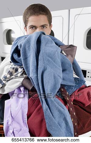 Man carrying a basket in a laundromat View Large Photo Image Stock Photograph - Man carrying a basket in a laundromat. Fotosearch
