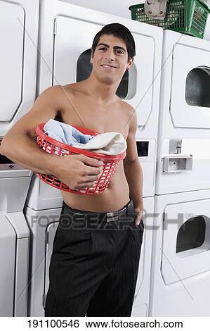 Man carrying a laundry basket in a laundromat View Large Photo Image Stock Photograph - Man carrying a laundry basket in a laundromat. Fotosearch