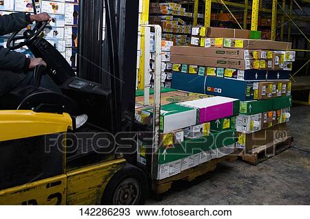 Stock Image - Man carrying flower boxes on a forklift, Miami, Florida, USA. Fotosearch