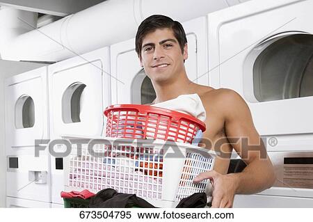 Man carrying laundry baskets in a laundromat View Large Photo Image Stock Photography - Man carrying laundry baskets in a laundromat. Fotosearch