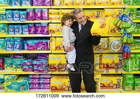Man choosing a diaper packet with his son in a supermarket View Large Photo Image Stock Photo - Man choosing a diaper packet with his son in a supermarket. Fotosearch