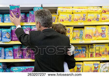 Man choosing a diaper packet with his son in a supermarket View Large Photo Image Stock Photo - Man choosing a diaper packet with his son in a supermarket. Fotosearch
