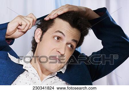 Picture - Man combing his hair. Fotosearch