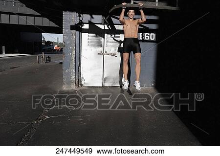 Man doing chin-ups in a street View Large Photo Image Stock Photo - Man doing chin-ups in a street. Fotosearch