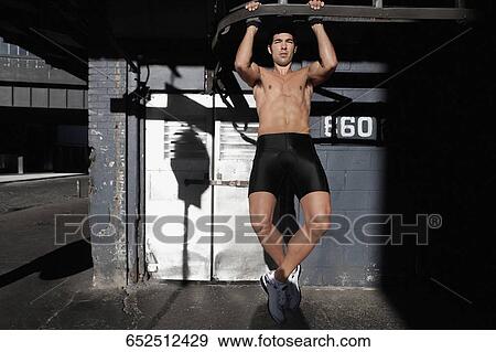 Man doing chin-ups in a street View Large Photo Image Stock Photo - Man doing chin-ups in a street. Fotosearch