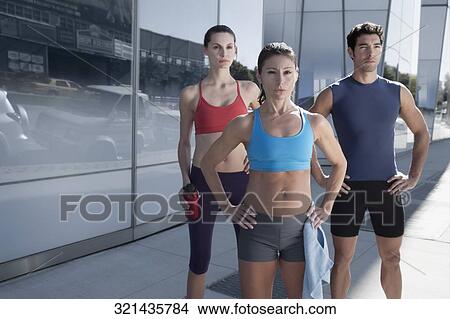 Man exercising with two women in front of a building View Large Photo Image Picture - Man exercising with two women in front of a building. Fotosearch
