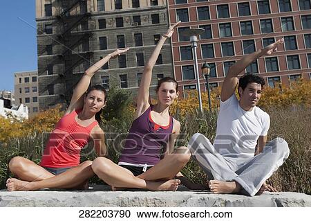 Man exercising with two women on a rock View Large Photo Image Stock Image - Man exercising with two women on a rock. Fotosearch