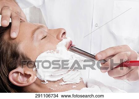 Man getting shaved in a salon View Large Photo Image Picture - Man getting shaved in a salon. Fotosearch