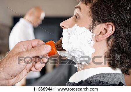 Stock Image - Man getting shaved in a salon. Fotosearch