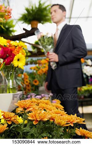 Man holding a bouquet of flowers View Large Photo Image Picture - Man holding a bouquet of flowers. Fotosearch