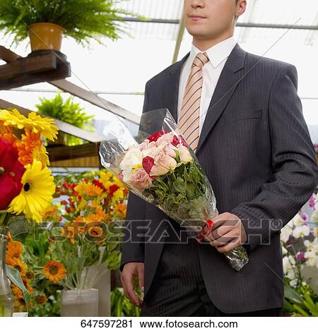 Man holding a bouquet of flowers View Large Photo Image Stock Image - Man holding a bouquet of flowers. Fotosearch