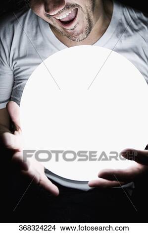 Man holding a crystal ball View Large Photo Image Picture - Man holding a crystal ball. Fotosearch