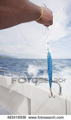 Man holding a fishing bait on a boat View Large Photo Image Stock Photograph - Man holding a fishing bait on a boat. Fotosearch