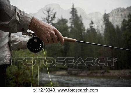 Man holding a fishing rod View Large Photo Image Stock Image - Man holding a fishing rod. Fotosearch