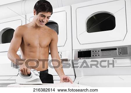 Man ironing a shirt and smiling View Large Photo Image Picture - Man ironing a shirt and smiling. Fotosearch