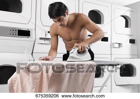 Stock Photograph - Man ironing a shirt. Fotosearch