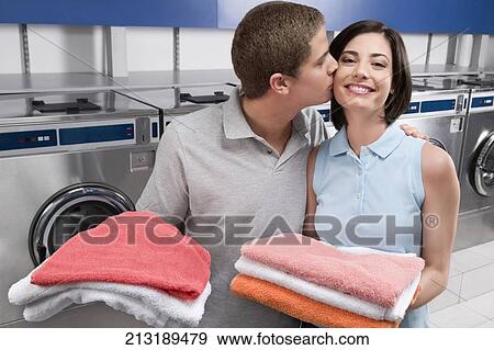 Man kissing a woman in a laundromat View Large Photo Image Stock Photo - Man kissing a woman in a laundromat. Fotosearch