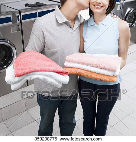 Man kissing a woman in a laundromat View Large Photo Image Stock Photography - Man kissing a woman in a laundromat. Fotosearch