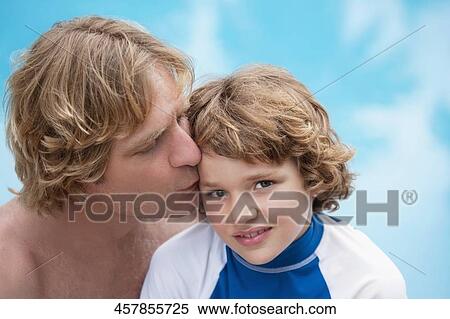 Stock Photography - Man kissing his son at the poolside. Fotosearch