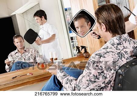 Man looking himself in a mirror after a haircut View Large Photo Image Stock Photo - Man looking himself in a mirror after a haircut. Fotosearch
