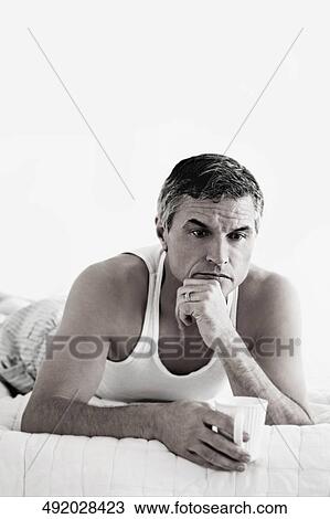 Man lying on the bed and thinking View Large Photo Image Stock Image - Man lying on the bed and thinking. Fotosearch