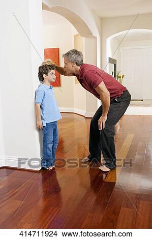 Man measuring his son's height View Large Photo Image Picture - Man measuring his son's height. Fotosearch