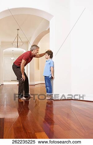 Man measuring his son's height View Large Photo Image Stock Photography - Man measuring his son's height. Fotosearch