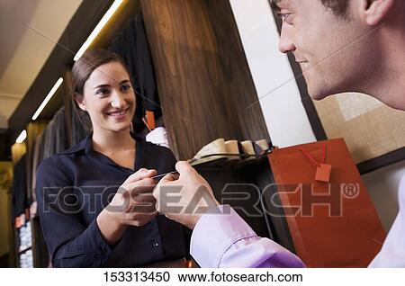 Man paying by a credit card in a store View Large Photo Image Stock Image - Man paying by a credit card in a store. Fotosearch
