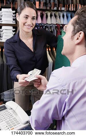 Man paying to a sales clerk in a clothing store View Large Photo Image Stock Image - Man paying to a sales clerk in a clothing store. Fotosearch