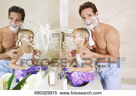 Stock Photography - Man playing with his daughter in the bathroom. Fotosearch