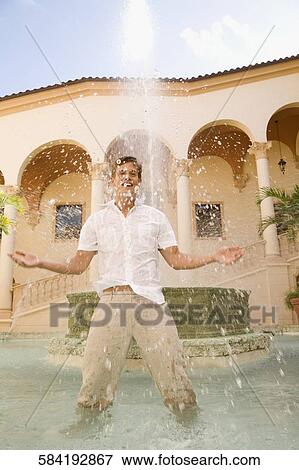 Stock Photo - Man playing with water under a fountain, Biltmore Hotel, Coral Gables, Florida, USA. Fotosearch