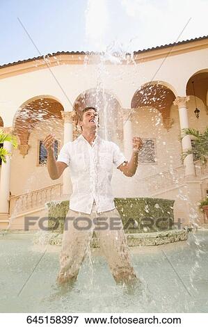 Stock Photo - Man playing with water under a fountain, Biltmore Hotel, Coral Gables, Florida, USA. Fotosearch