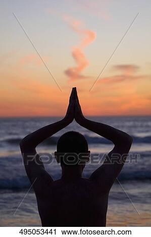 Stock Image - Man practicing yoga on the beach, Santa Monica, Los Angeles County, California, USA. Fotosearch
