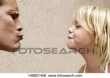 Man puckering his lips to kiss his daughter View Large Photo Image Stock Photograph - Man puckering his lips to kiss his daughter. Fotosearch