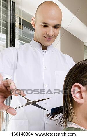 Man receiving a haircut in a salon View Large Photo Image Picture - Man receiving a haircut in a salon. Fotosearch