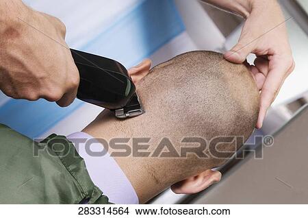 Picture - Man receiving a haircut in a salon. Fotosearch