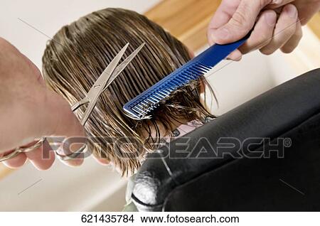 Picture - Man receiving a haircut in a salon. Fotosearch