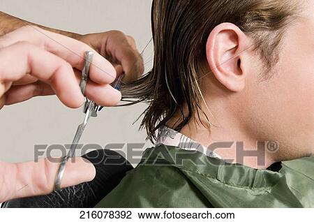 Stock Image - Man receiving a haircut in a salon. Fotosearch