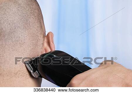 Stock Image - Man receiving a haircut in a salon. Fotosearch