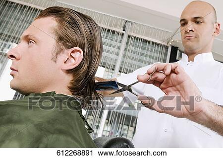 Man receiving a haircut in a salon View Large Photo Image Stock Image - Man receiving a haircut in a salon. Fotosearch