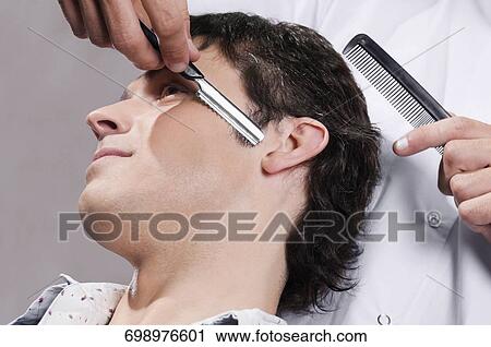 Man receiving a haircut in a salon View Large Photo Image Stock Image - Man receiving a haircut in a salon. Fotosearch