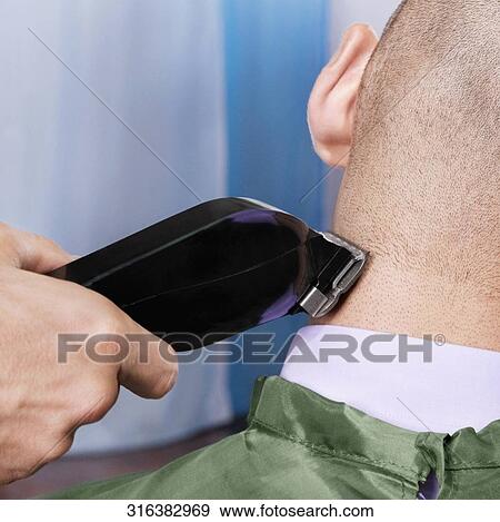 Man receiving a haircut in a salon View Large Photo Image Stock Photo - Man receiving a haircut in a salon. Fotosearch