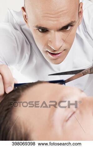 Man receiving a haircut in a salon View Large Photo Image Stock Photo - Man receiving a haircut in a salon. Fotosearch