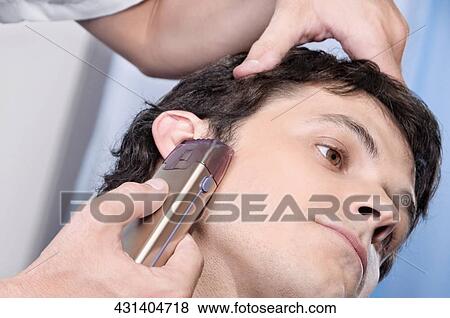 Man receiving a haircut in a salon View Large Photo Image Stock Photo - Man receiving a haircut in a salon. Fotosearch