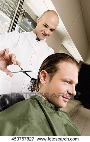 Stock Photo - Man receiving a haircut in a salon. Fotosearch