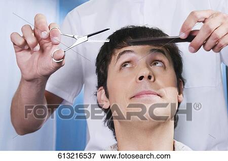 Stock Photo - Man receiving a haircut in a salon. Fotosearch