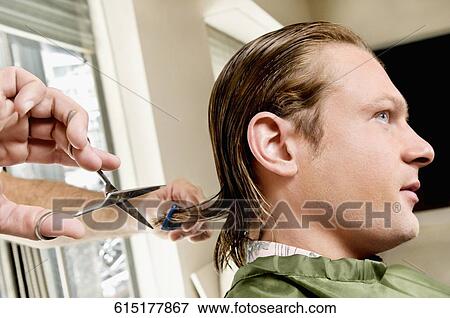 Man receiving a haircut in a salon View Large Photo Image Stock Photo - Man receiving a haircut in a salon. Fotosearch