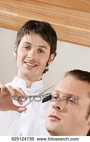 Man receiving a haircut in a salon View Large Photo Image Stock Photo - Man receiving a haircut in a salon. Fotosearch