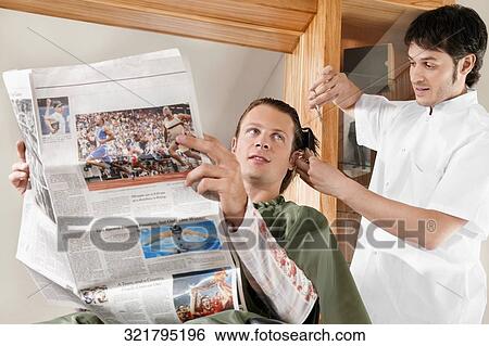 Man receiving a haircut in a salon View Large Photo Image Stock Photograph - Man receiving a haircut in a salon. Fotosearch
