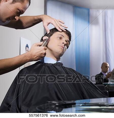 Stock Photograph - Man receiving a haircut in a salon. Fotosearch